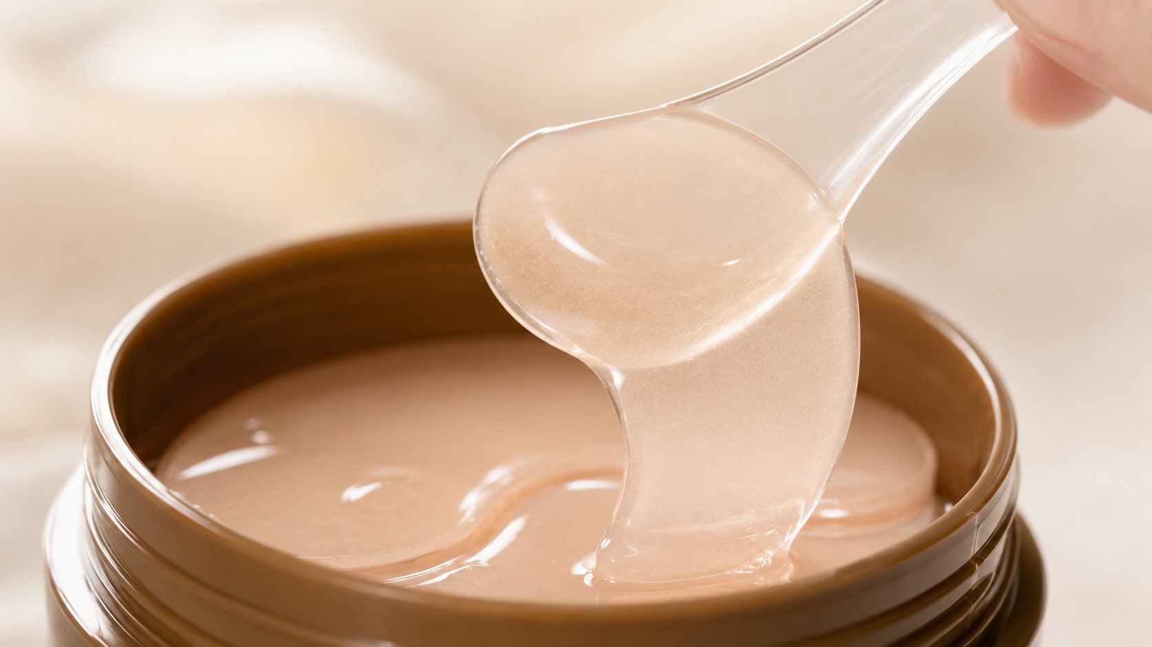MEDIHEAL Collagen Eye Patch hydrogel crescents being lifted with included spatula showing slippery texture