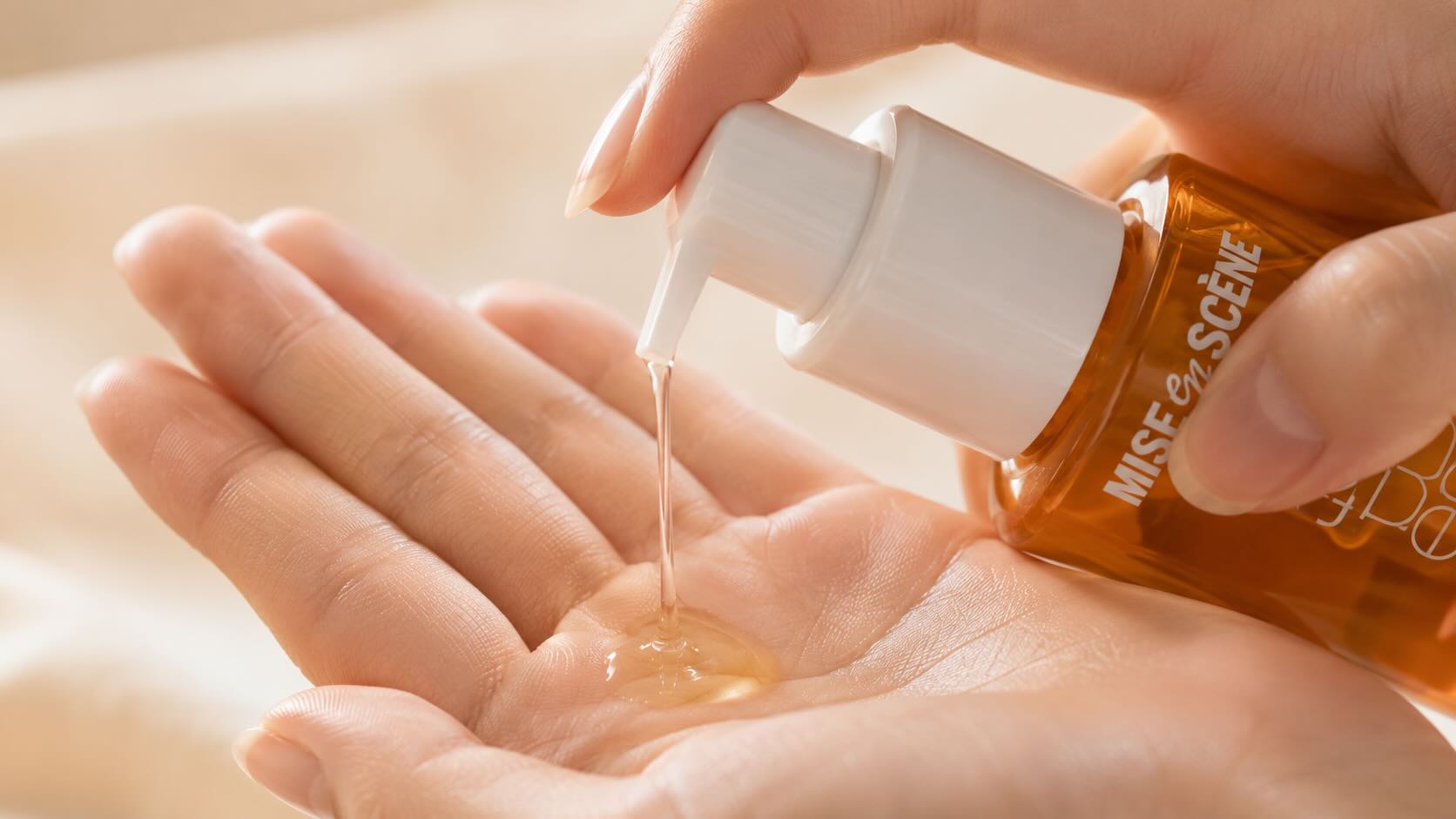 Mise en Scène Perfect Serum lightweight oil texture being dispensed onto palm showing golden serum