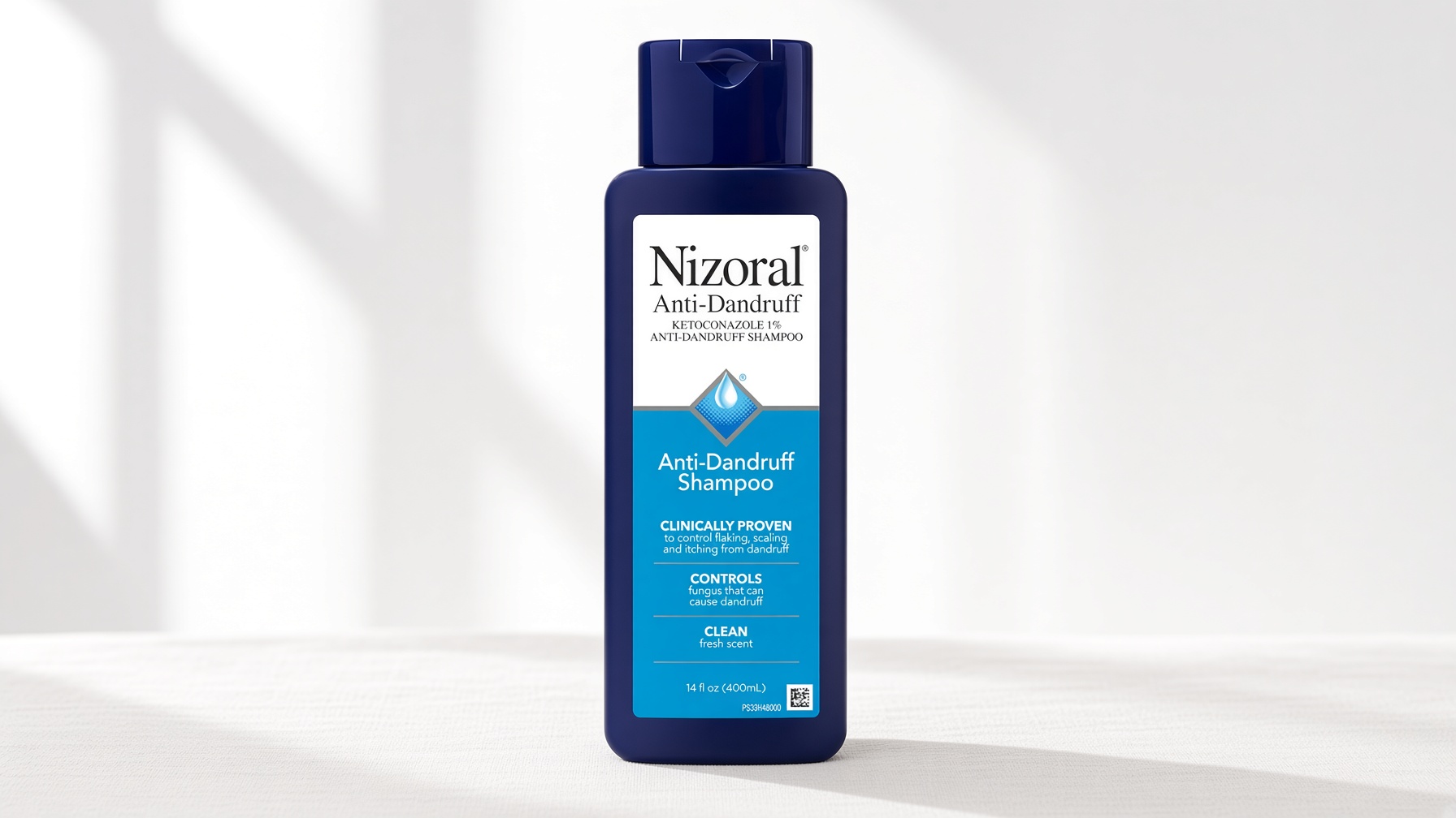Nizoral Anti-Dandruff Shampoo 1% Ketoconazole green bottle on neutral cream background