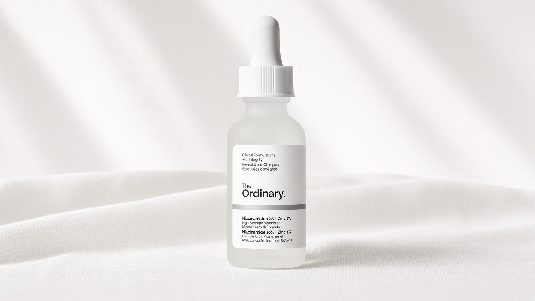 The Ordinary Niacinamide 10% + Zinc 1% serum bottle on neutral cream background with minimalist editorial styling