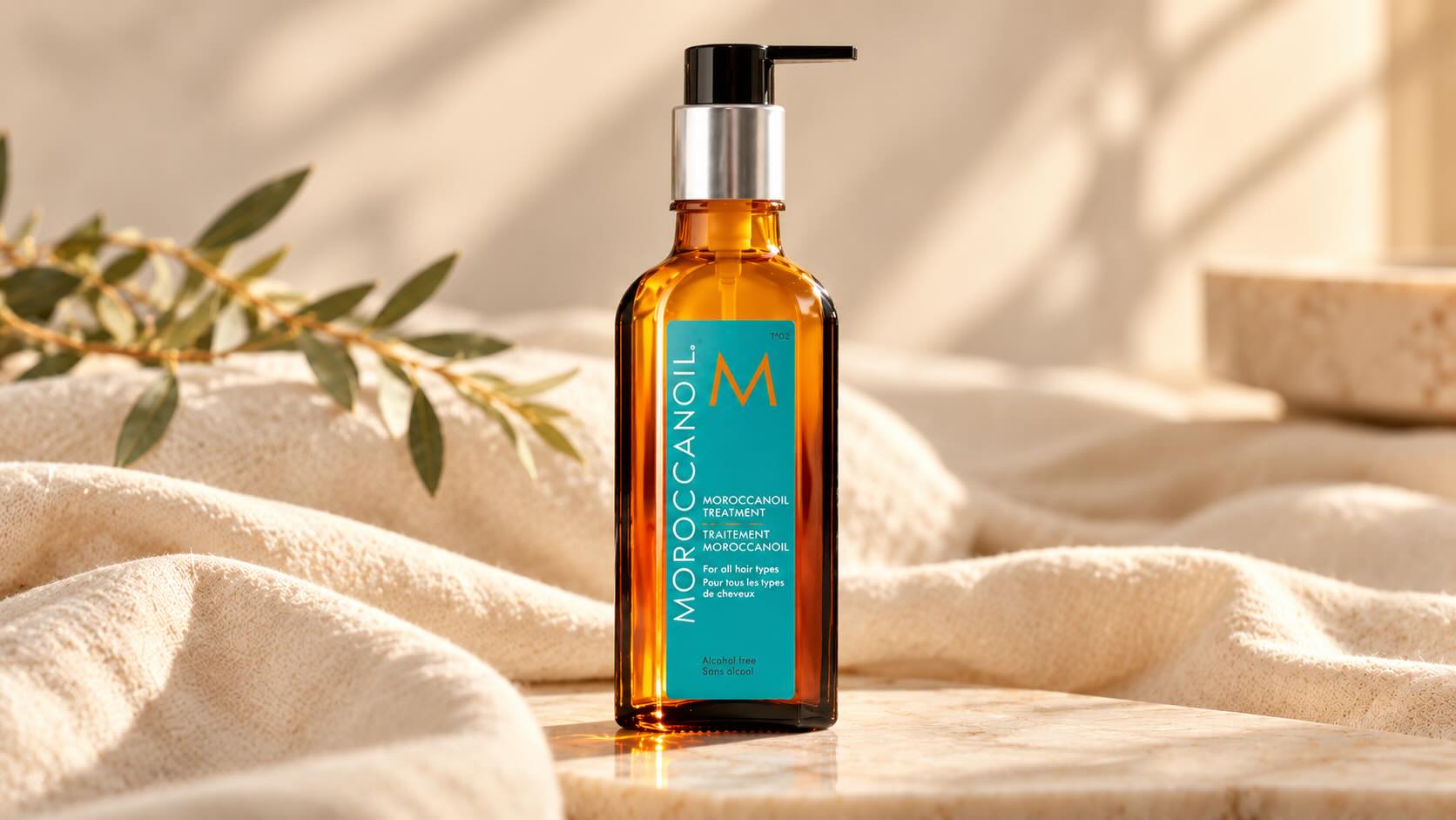 Moroccanoil Treatment Original brown glass bottle on neutral cream background with minimal elegant styling